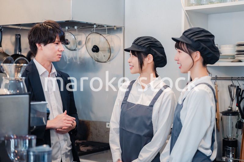 レストランのオーナーと話をするスタッフ