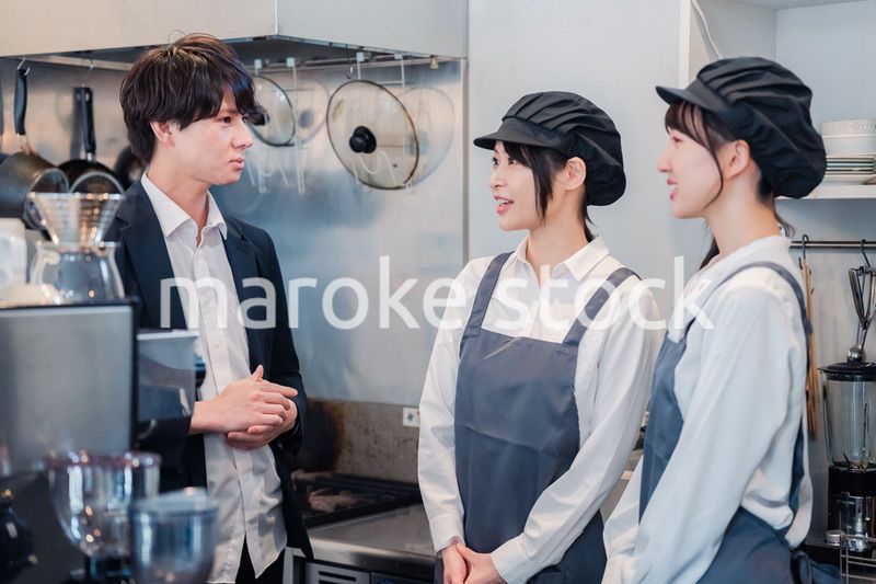 レストランのオーナーと話をするスタッフ