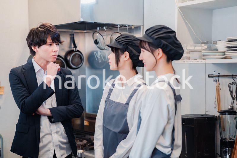 レストランのオーナーと話をするスタッフ