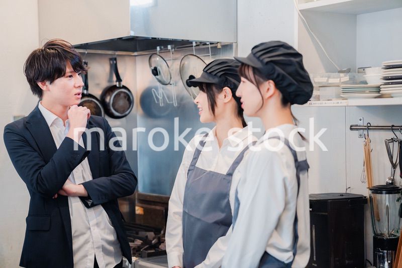 レストランのオーナーと話をするスタッフ