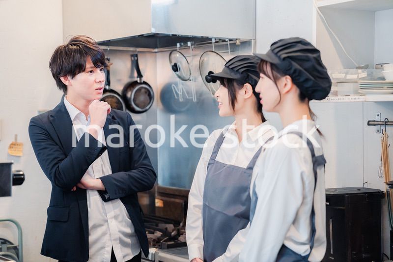 レストランのオーナーと話をするスタッフ