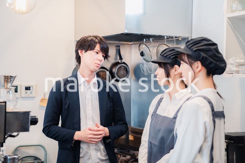 レストランのオーナーと話をするスタッフ