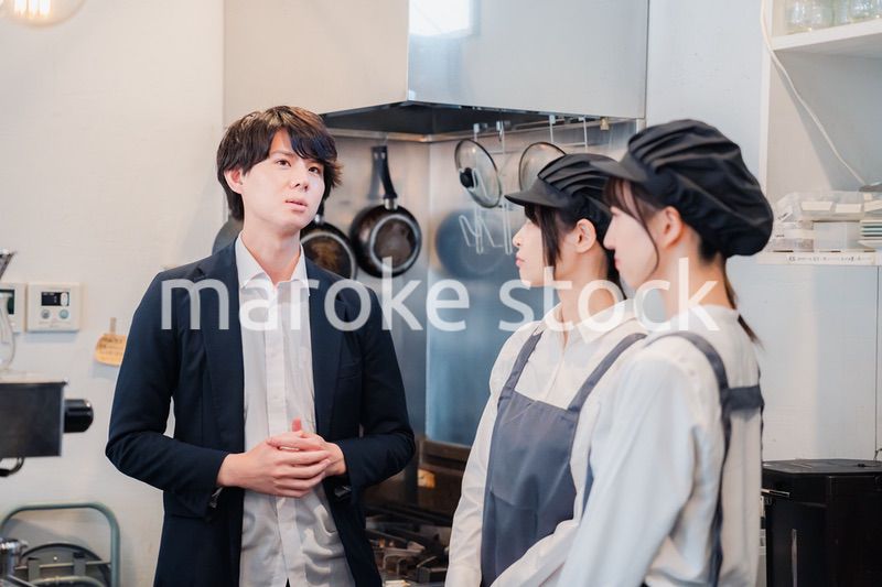 レストランのオーナーと話をするスタッフ