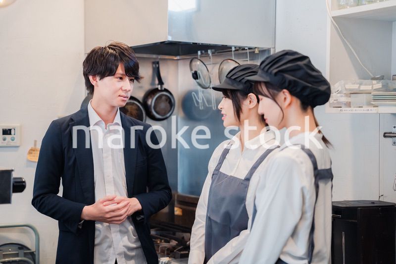 レストランのオーナーと話をするスタッフ