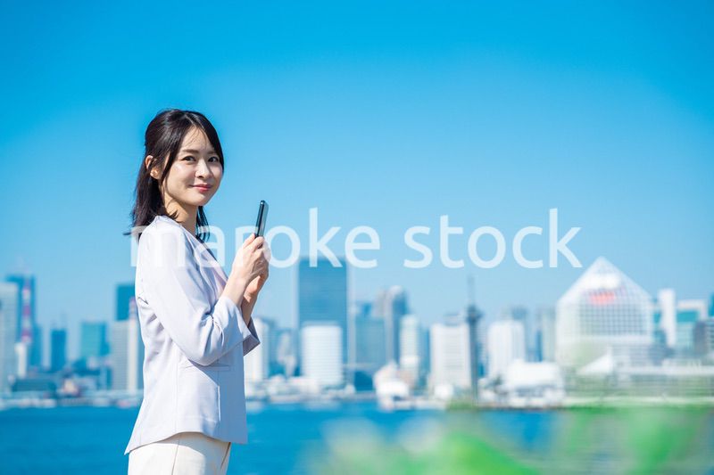外でスマホを使う若いビジネスウーマン
