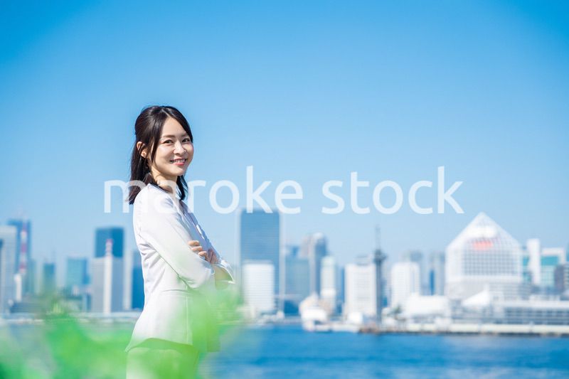 腕を組んで立つ女性ビジネスパーソン