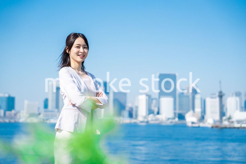 腕を組んで立つ女性ビジネスパーソン