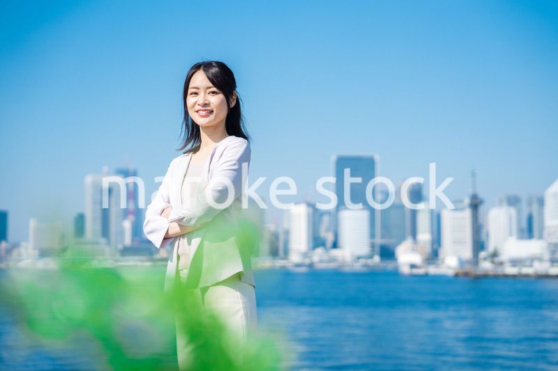 腕を組んで立つ女性ビジネスパーソン