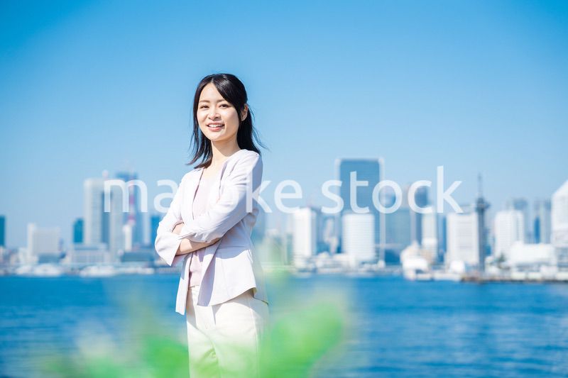 腕を組んで立つ女性ビジネスパーソン