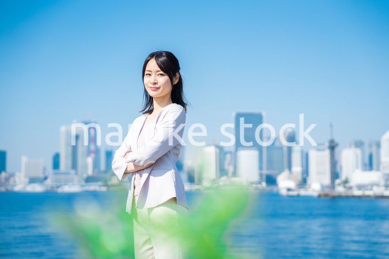 腕を組んで立つ女性ビジネスパーソン