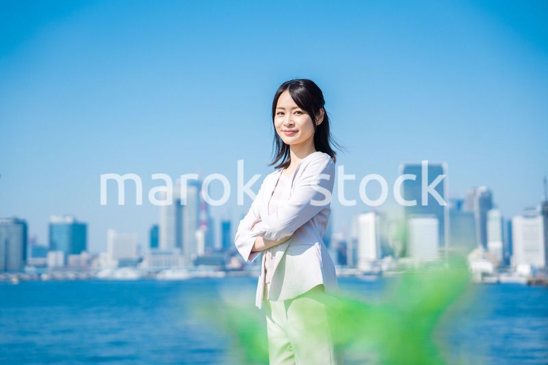 腕を組んで立つ女性ビジネスパーソン