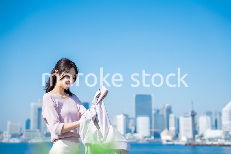 ジャケットを脱いで外を歩くビジネスウーマン