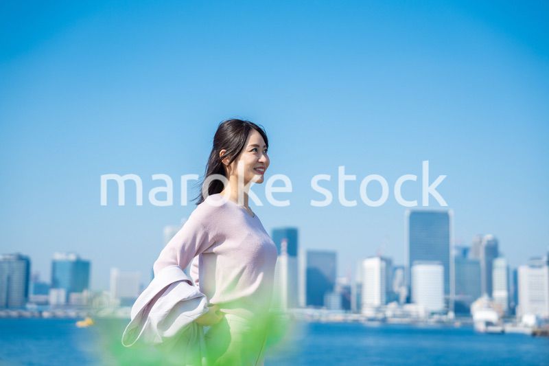ジャケットを脱いで外を歩くビジネスウーマン