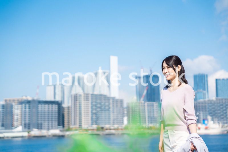 ジャケットを脱いで外を歩くビジネスウーマン