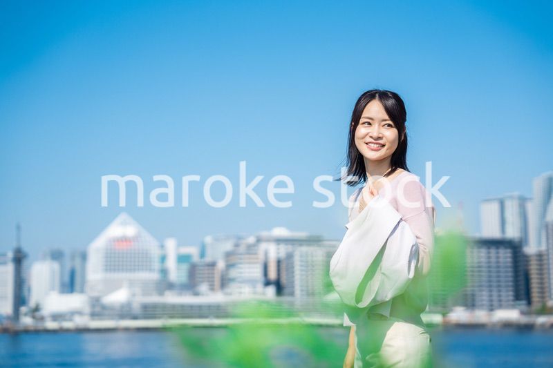 ジャケットを脱いで外を歩くビジネスウーマン