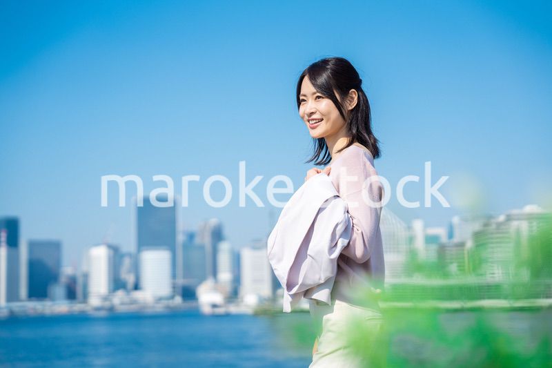 ジャケットを脱いで外を歩くビジネスウーマン