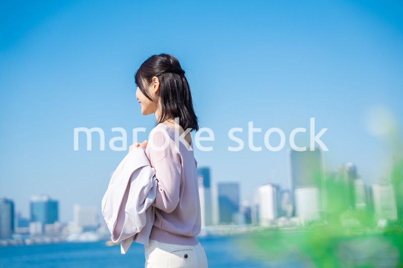 ジャケットを脱いで外を歩くビジネスウーマン