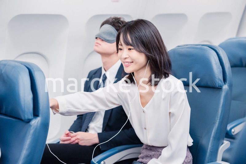 機内エンターテイメントを使う乗客