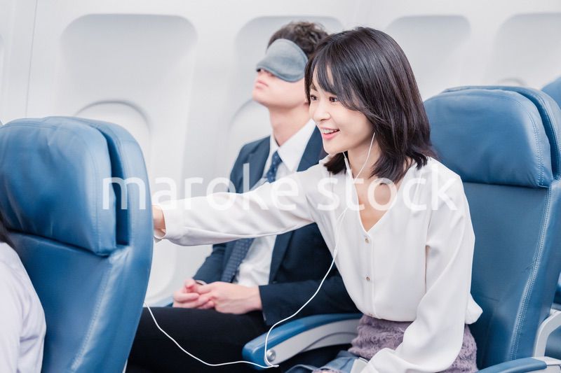 機内エンターテイメントを使う乗客