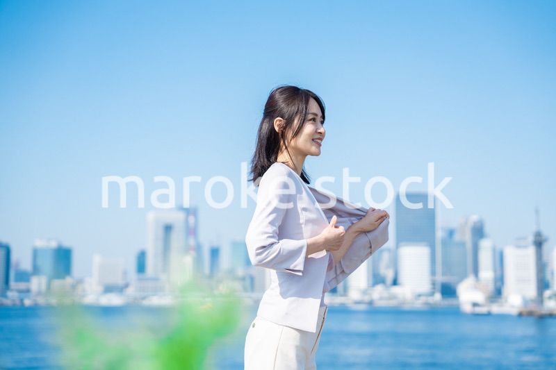 ジャケットを脱いで外を歩くビジネスウーマン