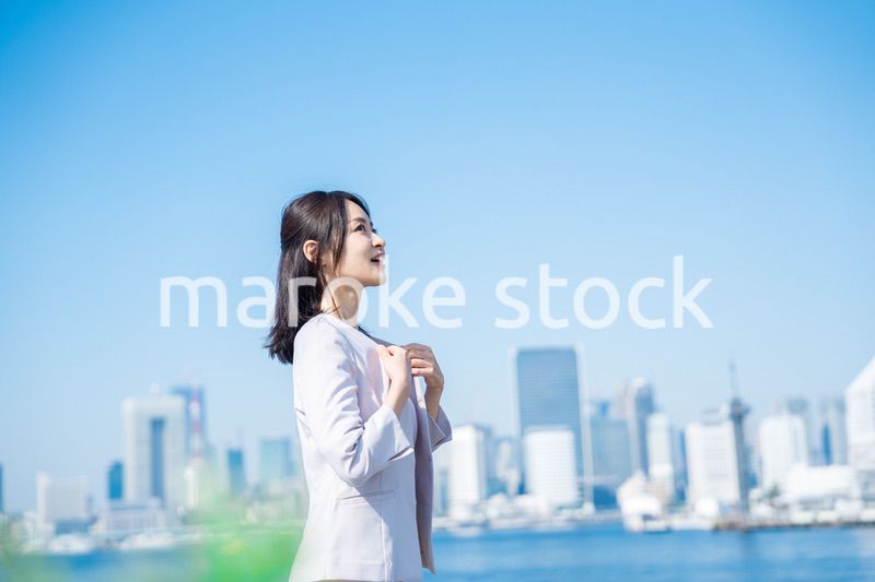 ジャケットを脱いで外を歩くビジネスウーマン