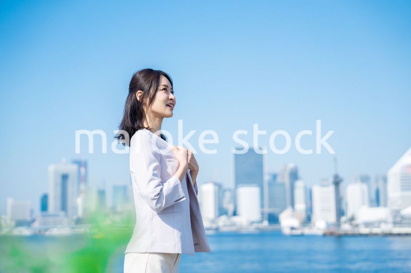 ジャケットを脱いで外を歩くビジネスウーマン