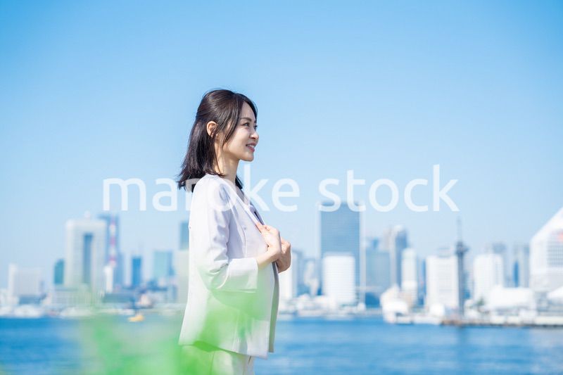 ジャケットを脱いで外を歩くビジネスウーマン
