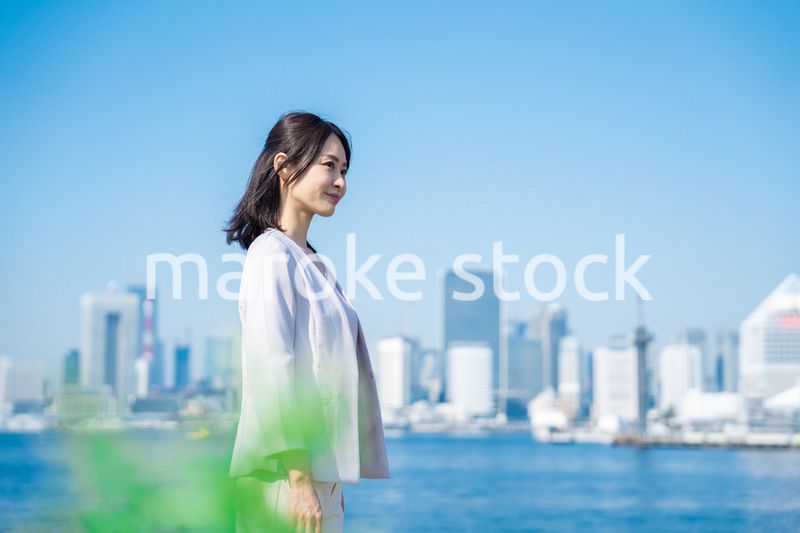 ジャケットを脱いで外を歩くビジネスウーマン