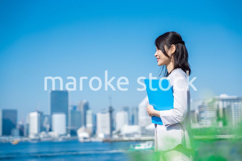 書類を持って外を歩くビジネスウーマン