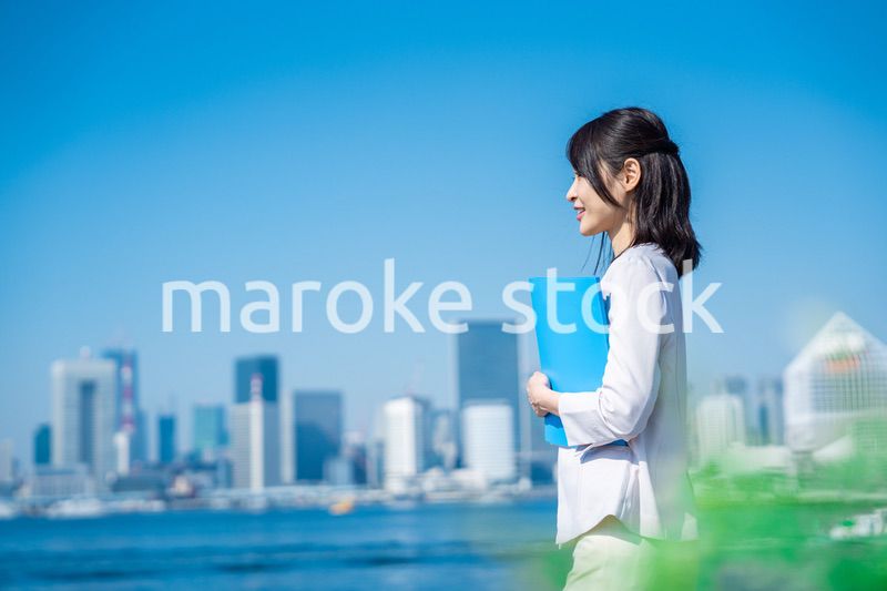 書類を持って外を歩くビジネスウーマン