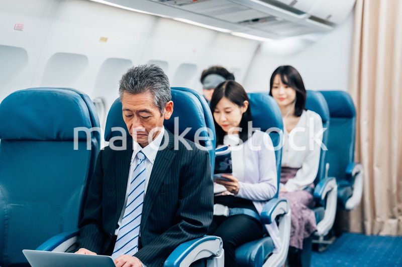 飛行機で出張に出かけるミドルのビジネスマン