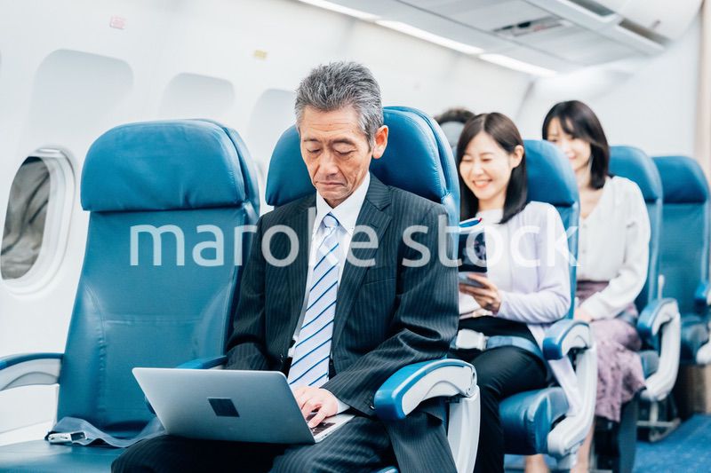飛行機で出張に出かけるミドルのビジネスマン