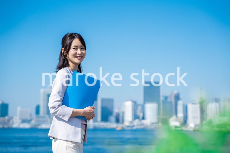 書類を持って外を歩くビジネスウーマン