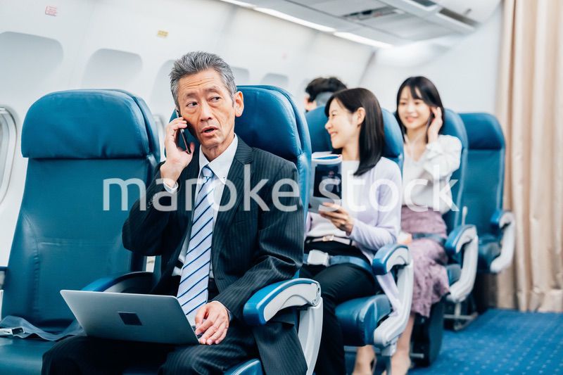 飛行機で出張に出かけるミドルのビジネスマン