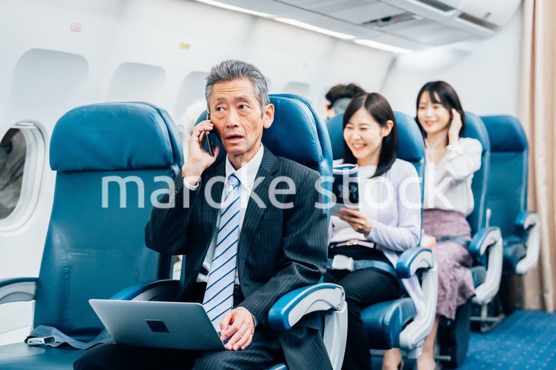 飛行機で出張に出かけるミドルのビジネスマン