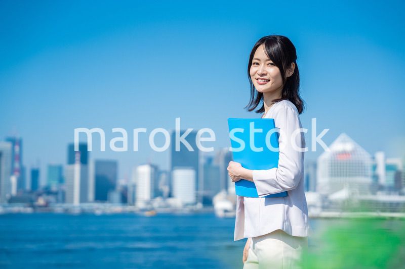 書類を持って外を歩くビジネスウーマン