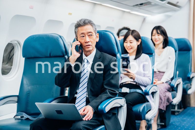 飛行機で出張に出かけるミドルのビジネスマン
