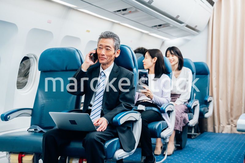 飛行機で出張に出かけるミドルのビジネスマン
