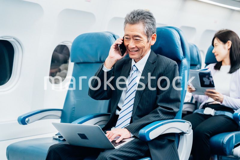 飛行機で出張に出かけるミドルのビジネスマン