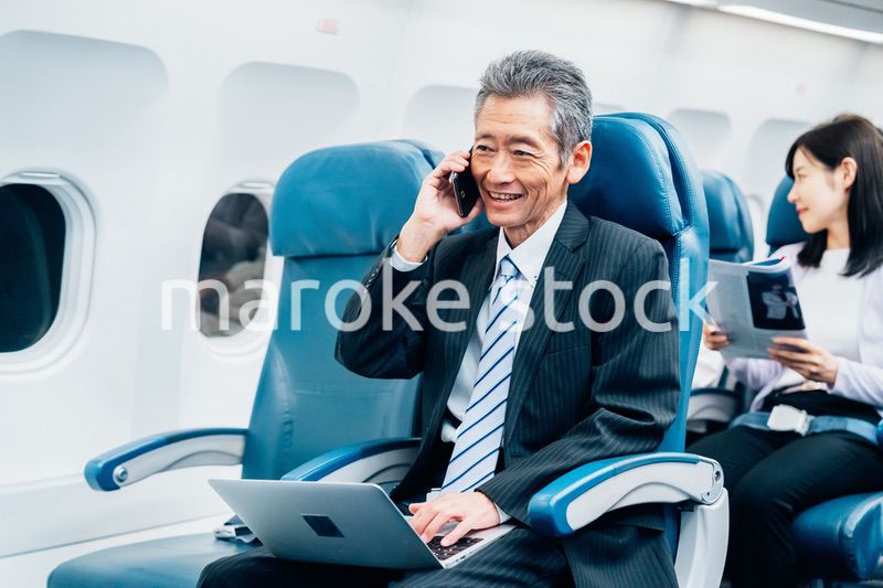 飛行機で出張に出かけるミドルのビジネスマン