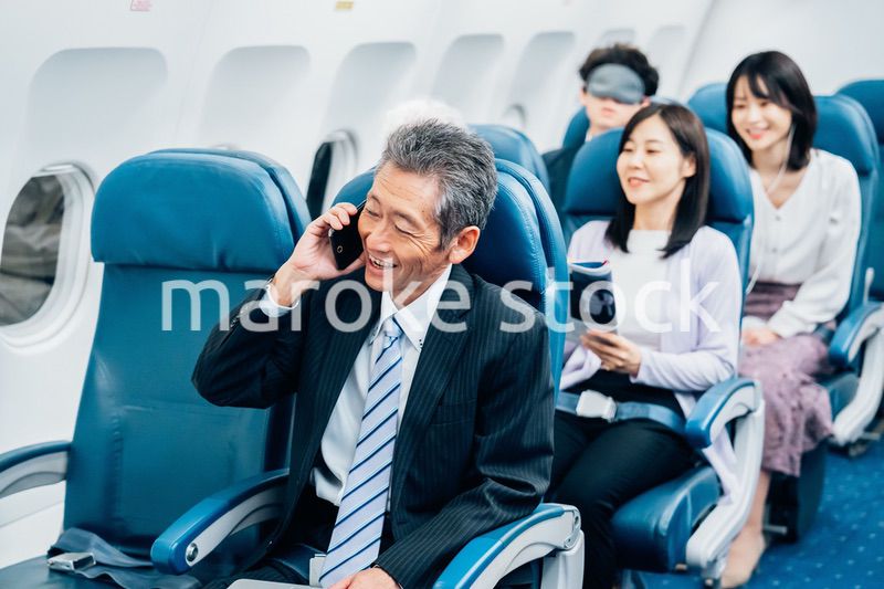 飛行機で出張に出かけるミドルのビジネスマン