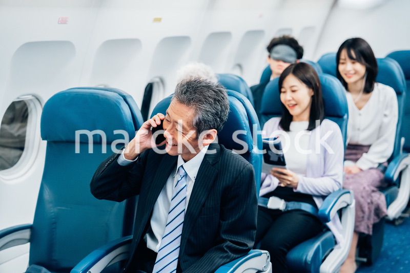 飛行機で出張に出かけるミドルのビジネスマン