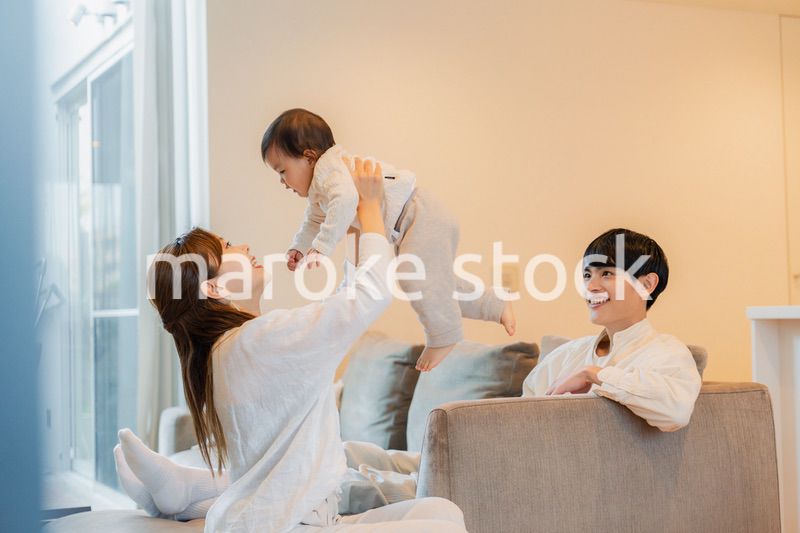 赤ちゃんと高い高いをして遊ぶファミリー