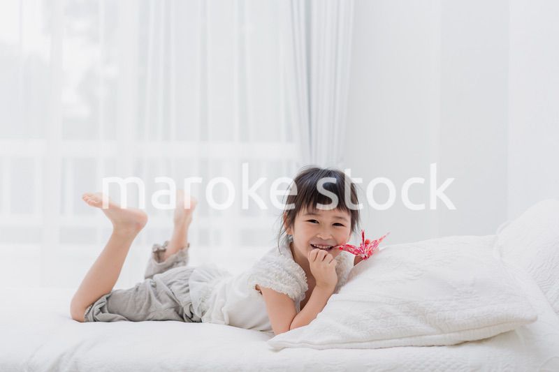 ベッドに寝転がる小さな女の子