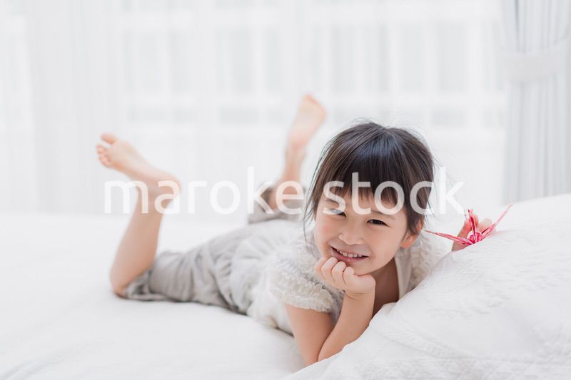 ベッドに寝転がる小さな女の子