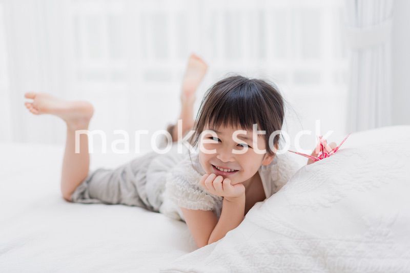 ベッドに寝転がる小さな女の子