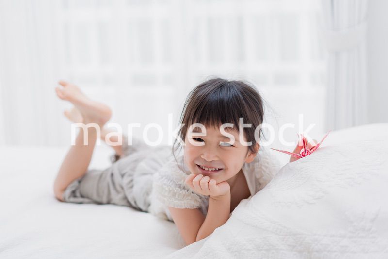 ベッドに寝転がる小さな女の子