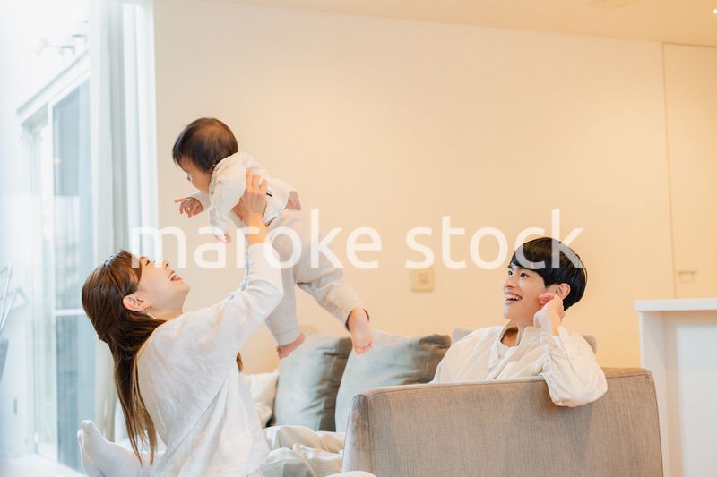赤ちゃんと高い高いをして遊ぶファミリー