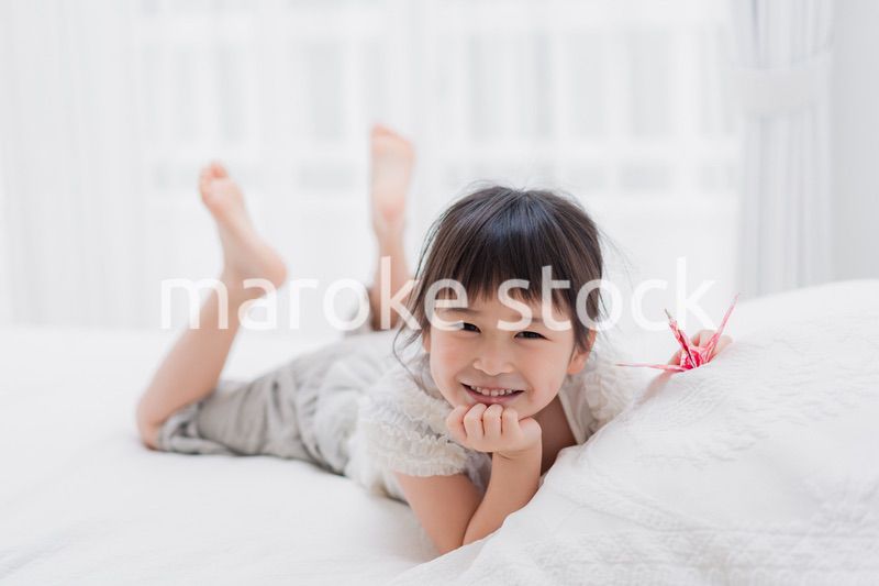ベッドに寝転がる小さな女の子