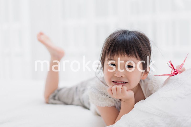 ベッドに寝転がる小さな女の子